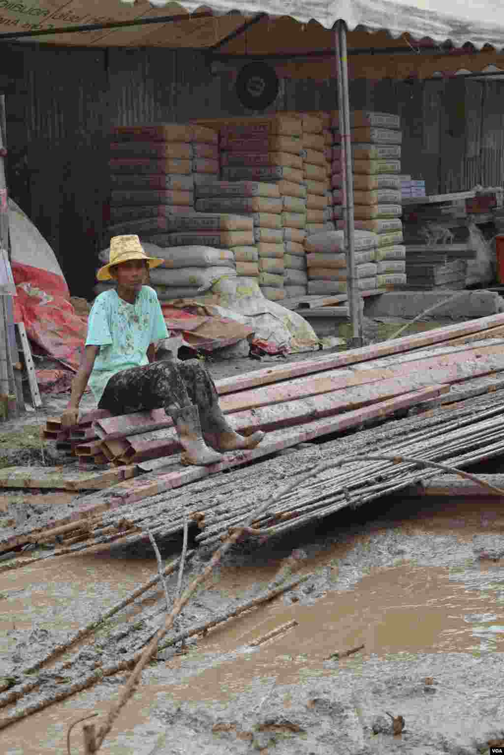 A worker takes a break at a muddy construction site in Bangkok, July 10, 2014. (Rosyla Kalden/VOA)