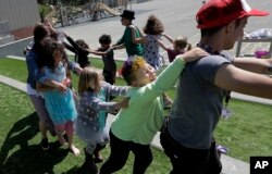 FILE - Campers and camp counselors dance at the Bay Area Rainbow Day Camp in El Cerrito, Calif., July 11, 2017.