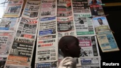 FILE - A boy walks past a newspaper kiosk at the Carrefour Wada district in Cameroon's capital Yaounde, Oct. 7, 2011. The country's National Communication Council has suspended dozens of media outlets and journalists for what is calls biased reporting.