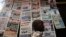 FILE - A boy walks past a newspaper kiosk at the Carrefour Wada district in Cameroon's capital Yaounde, Oct. 7, 2011. The country's National Communication Council has suspended dozens of media outlets and journalists for what is calls biased reporting.