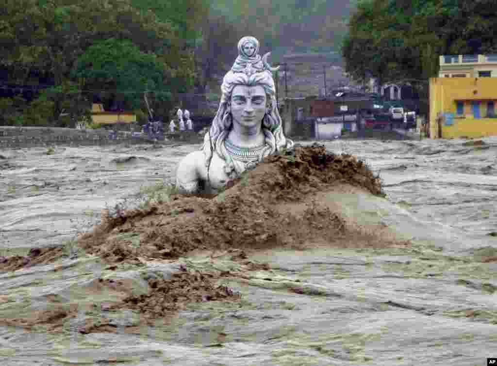 A submerged idol of Hindu Lord Shiva stands in the flooded River Ganges in Rishikesh, in the northern Indian state of Uttarakhand, India, Tuesday, June 18, 2013. Monsoon torrential rains have cause havoc in northern India leading to flash floods, cloudbur