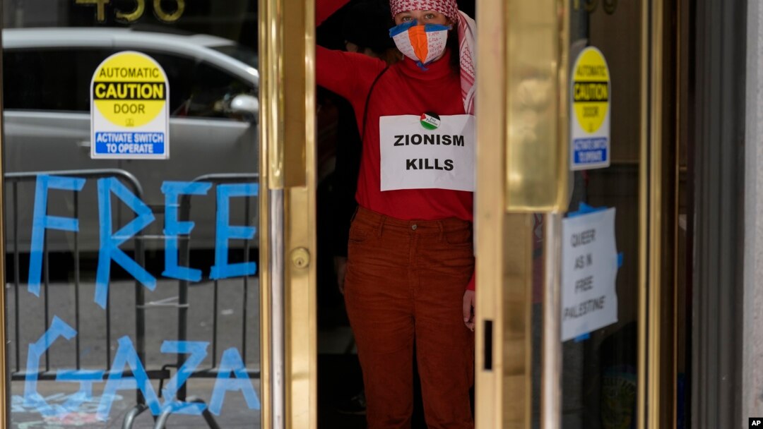 Manifestante pro-Palestina levanta los puños mientras ocupa el vestíbulo de un edificio en el que se encuentra el consulado israelí en San Francisco, el lunes 3 de junio de 2024.