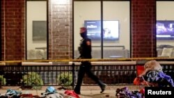 Seorang polisi memeriksa lokasi kejadian di mana sebuah mobil menabrak rombongan parade natal di Waukesha, Wisconsin, pada 21 November 2021. (Foto: USA Today Network via Reuters/Mike De Sisti)