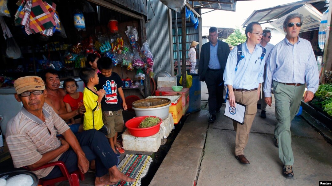 Ngoại trưởng Hoa Kỳ John Kerry (phải) đến thăm ấp Kiến Vàng nằm bên bờ sông Mekong, Việt Nam, ngày 15 tháng 12 năm 2013.