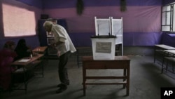 Egyptian man speaks to election workers during runoff of first-round parliamentary elections, Al-Haram in Giza, a neighboring city of Cairo, Oct. 27, 2015.