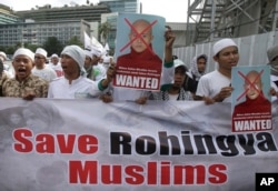 FILE - Indonesian Muslims hold defaced posters of Myanmar's radical Buddhist monk Ashin Wirathu during a protest demanding an end to the violence against ethnic Rohingyas in Rakhine State, outside the Embassy of Myanmar in Jakarta, Indonesia, May 27, 2015.