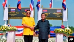 In this photo released by the Government Spokesman's Office, Thailand's Prime Minister Prayuth Chan-ocha (L) shakes hand with Cambodian's Prime Minister Hun Sen at the Thai-Cambodian border town of Aranyaprathet, Thailand, April 22, 2019.
