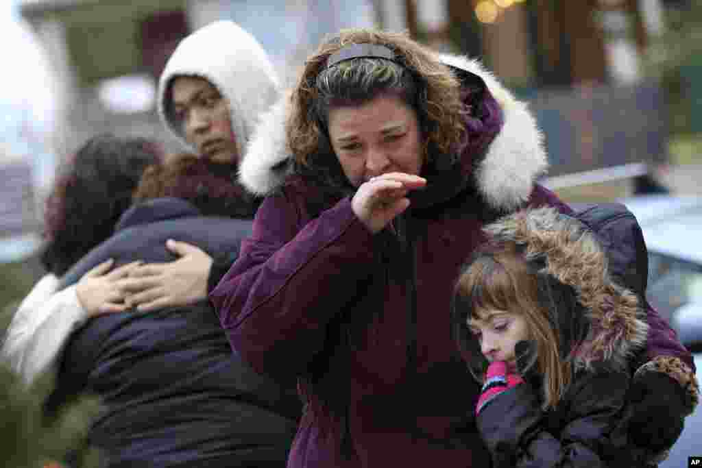 Mourners grieve at one of the makeshift memorials for victims of the Sandy Hook Elementary School shooting, December 16, 2012, in Newtown, Conn. 