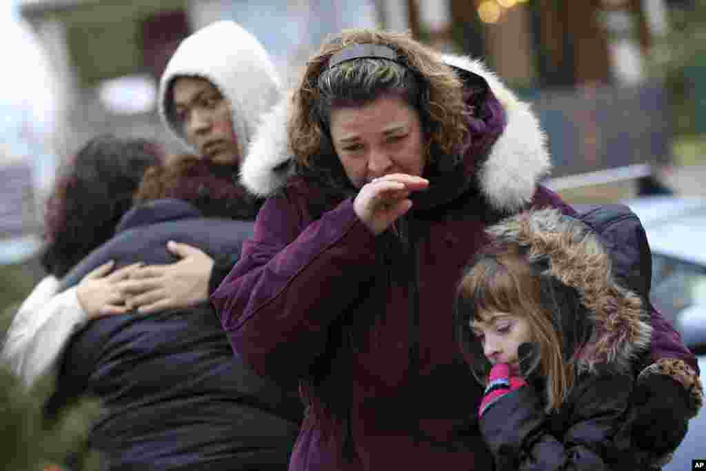 Mourners grieve at one of the makeshift memorials for victims of the Sandy Hook Elementary School shooting, December 16, 2012, in Newtown, Conn.