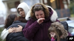 Mourners grieve at one of the makeshift memorials for victims of the Sandy Hook Elementary School shooting, December 16, 2012, in Newtown, Conn. 