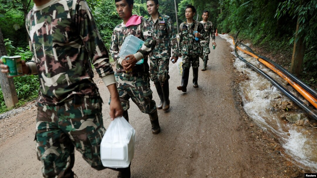 Para petugas penyelamat membawa bantuan di dekat komplek gua Tham Luang, di Provinsi Chiang Rai, di utara Thailand, 4 Juli 2018. 