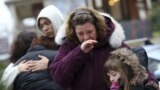 Mourners grieve at one of the makeshift memorials for victims of the Sandy Hook Elementary School shooting, December 16, 2012, in Newtown, Conn. 