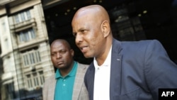 Joseph Mathunjwa (R), President of the Association of Mineworkers and Construction Union (AMCU) arrives at a mediation meeting in Johannesburg, Jan. 24, 2014. 