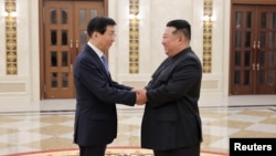 북한 김정은 국무위원장(사진 오른쪽)이 7월 16일 북한 평양을 방문한 왕후닝 중국 인민정치협상회의(정협) 주석과 악수하고 있다.