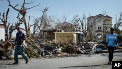 Residents walk through wrecked streets and homes after the passage of Hurricane Irma, in Phillipsburg, St. Martin, Sept. 11, 2017. 