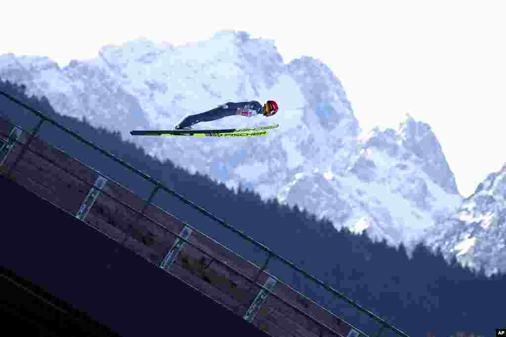 Philipp Aschenwald of Austria soars through the air, with Germany&#39;s highest mountain, the Zugspitze, in the background, during a trial jump at the second stage of the 69th Four Hills ski jumping tournament in Garmisch-Partenkirchen, Germany.