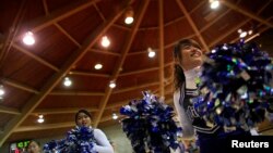 FILE - Foreign exchange students Taiwan and China cheer during a girls’ basketball game in Waverly, South Dakota, Feb. 14, 2012. 