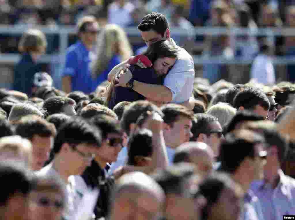 Students console one another at the University of California Santa Barbara&#39;s Harder Stadium during a memorial service in honor of the victims of Isla Vista rampage in Santa Barbara, California. Students returned to campus for a &quot;day of mourning&quot;, four days after the son of a Hollywood film director killed six students in a stabbing and shooting rampage across the seaside community.