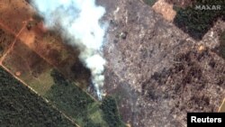 A satellite image shows smoke rising from Amazon rainforest fires in the State of Rondonia, just southwest of Porto Velho, Brazil in the upper Amazon River basin on August 15, 2019.