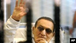 Mantan Presiden Mesir, Hosni Mubarak, melambaikan tangan kepada para pendukungnya, saat menghadiri sidang di pengadilan Kairo (13/4).