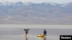 Jay Coley, left, and Dede Barney, both of St. George, Utah, are on Lake Manly, a temporary lake formed by heavy rain, at Death Valley National Park, California, Feb. 24, 2024. The lake is located at Badwater Basin, the lowest point in North America at 282 feet below sea level.