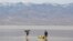 Jay Coley, left, and Dede Barney, both of St. George, Utah, are on Lake Manly, a temporary lake formed by heavy rain, at Death Valley National Park, California, Feb. 24, 2024. The lake is located at Badwater Basin, the lowest point in North America at 282 feet below sea level.