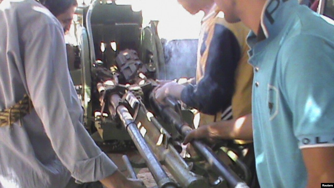 Para pemberontak Suriah mengoperasikan persenjataan yang berhasil mereka rampas dari tentara pemerintah (18/9). 