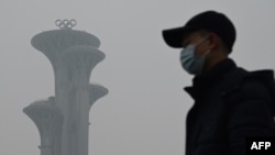 一名男子在霧霾天走在北京奧林匹克公園裡。 （2022年1月24日）
