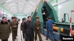 Pemimpin Korea Utara Kim Jong Un mengunjungi sebuah pabrik senjata yang memproduksi "sistem senjata utama" di lokasi yang disembunyikan, demikian informasi dan foto yang dirilis oleh KCNA pada 28 Januari 2022. (Foto: KCNA via Reuters)