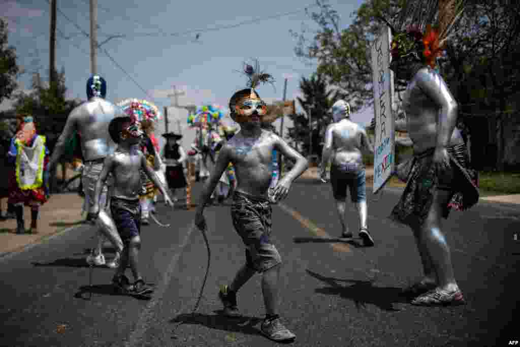 Young residents of San Nicolas de los Ranchos community in Puebla state, Mexico, with their bodies painted with oil and using masks parade and dance as &quot;Xinacates&quot; in the town&#39;s traditional carnival, March 31, 2019.
