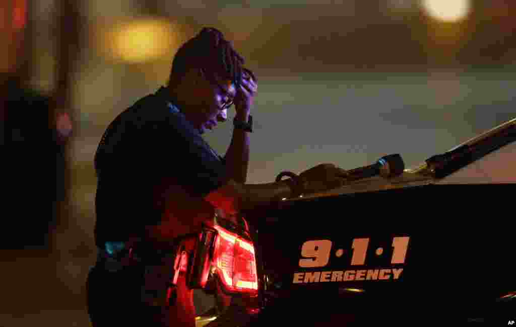 Une policière se recueille en apprenant la mort de cinq de ses collègues tués par des snipers dans une fusillade à Dallas, 8 juillet 2016. (AP Photo / LM Otero)