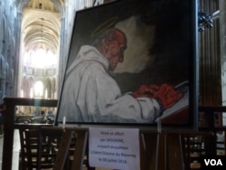 A painting of the late Father Jacques Hamel, the Catholic priest killed by jihadists while celebrating Mass at his church in St. Etienne du Rouvray, hangs at Rouen's cathedral. The painting was done by Moubine, a Muslim artist. (L. Ramirez/VOA)