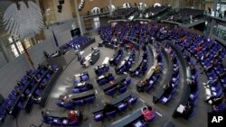 Due to the new coronavirus outbreak, German lawmakers keep distance during a session of the lower house of the German Parliament, the Bundestag, at the Reichstag building in Berlin, Germany, March 25, 2020. 