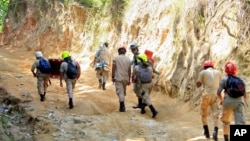 Rescue workers arrive at a gold mine where a landslide trapped miners in San Juan Arriba, Honduras, July 6, 2014.