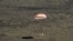 La cápsula Soyuz con tres astronautas a bordo desciende con ayuda de un paracaídas en las estepas de Kazijistán el 17 de abril de 2020.