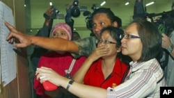 亲属在雅加达哈利姆机场含泪查看失事飞机的乘客名单