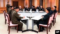  In this Oct. 16, 2018, photo provided by S. Korea Defense Ministry, the U.S.-led UNC, center, S. Korean and N. Korean, left, military officers attend a meeting at the southern side of Panmunjom in the DMZ, South Korea. 
