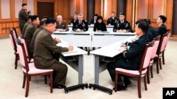 In this Oct. 16, 2018, photo provided by S. Korea Defense Ministry, the U.S.-led UNC, center, South Korean and North Korean, left, military officers attend a meeting at the southern side of Panmunjom in the DMZ, South Korea. 