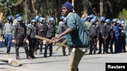 A demonstrator reacts after anti-riot police use batons to break up a peaceful march protesting the Zimbabwe government's handling of the economy, in Harare, Aug. 3, 2016.