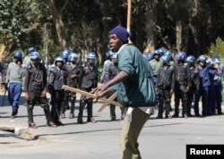 A demonstrator reacts after anti-riot police use batons to break up a peaceful march protesting the Zimbabwe government's handling of the economy, in Harare, Aug. 3, 2016.