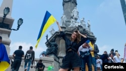 ARCHIVO - La modelo y periodista ucraniana Alona Goncharuk posa con una bandera de su país, en el Ángel de la Independencia, en Ciudad de México, donde vive desde abril de 2022, debido a la gran invasión rusa en Ucrania.