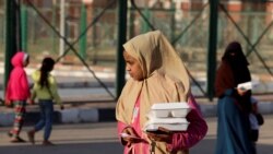FILE —A girl takes her meal from the Egyptian Food Bank mobile kitchen as they work to distribute 1.5 million hot meals to support the poor during the holy month of Ramadan, in Cairo, Egypt, March 19, 2024.
