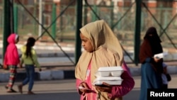 FILE —A girl takes her meal from the Egyptian Food Bank mobile kitchen as they work to distribute 1.5 million hot meals to support the poor during the holy month of Ramadan, in Cairo, Egypt, March 19, 2024.