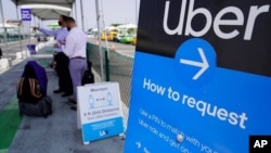 Viajeros esperan por sus conductores de Uber y Lyft en el aeropuerto de Los Angeles.