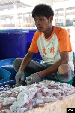 Công nhân nhập cư Miến Điện rửa mực tại chợ thủy sản làm sạch mực tại chợ thủy sản Talay Thái ở Samutsakhon.