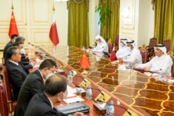 FILE - Qatari Foreign Minister Sheikh Mohammed bin Abdulrahman al-Thani (R) meets with China's Foreign Minister and State Councillor Wang Yi and his delegation in Doha, Oct. 26, 2021.