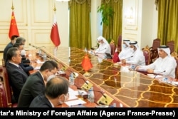 FILE - Qatari Foreign Minister Sheikh Mohammed bin Abdulrahman al-Thani (R) meets with China's Foreign Minister and State Councillor Wang Yi and his delegation in Doha, Oct. 26, 2021.