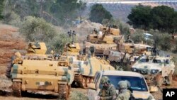 FILE - Turkish troops take control of Bursayah hill, which separates the Kurdish-held enclave of Afrin from the Turkey-controlled town of Azaz, Syria, Jan. 28, 2018. 