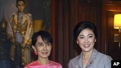 Thai Prime Minister Yingluck Shinawatra, right, stands with Myanmar pro-democracy leader Aung San Suu Kyi during a meeting at the Thai Embassy in Yangon, Myanmar, December 20, 2011.