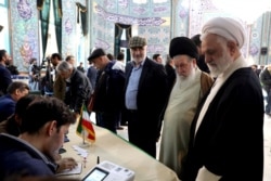 Men register to cast their vote during parliamentary elections, at a polling station in Tehran, Iran, Feb. 21, 2020.
